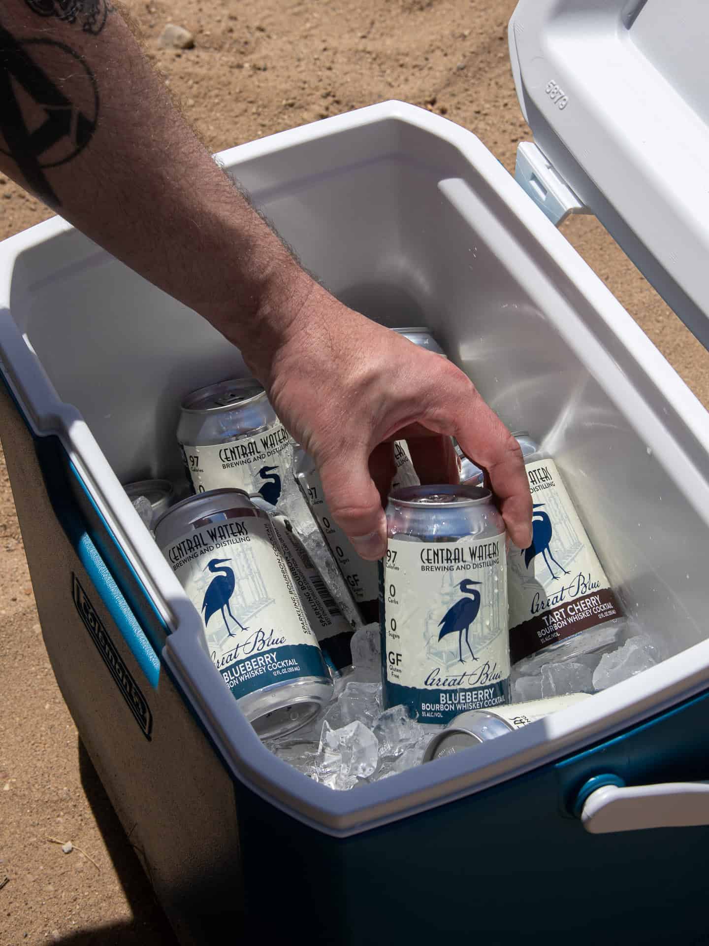 Reaching into a cooler full of iced Great Blue cans